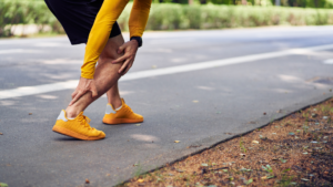 Man grabbing achilles tendon while walking