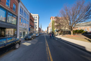 Parked cars and people visiting different shopping boutiques along downtown MiddletownMiddletown's downtown shopping district. Looking down North Street.