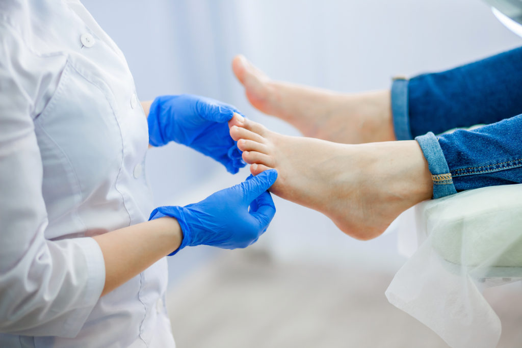Podiatrist examines patients feet